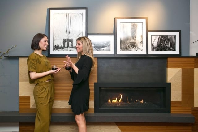 Two Women Standing In Front Of FirePlace In The Den At The Fifty