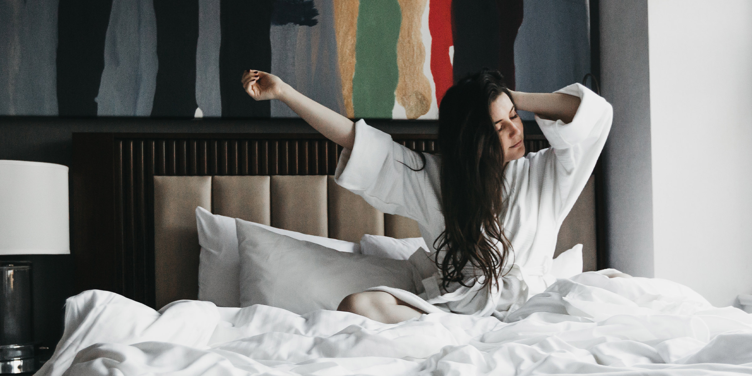 Woman in robe on a bed at the Fifty